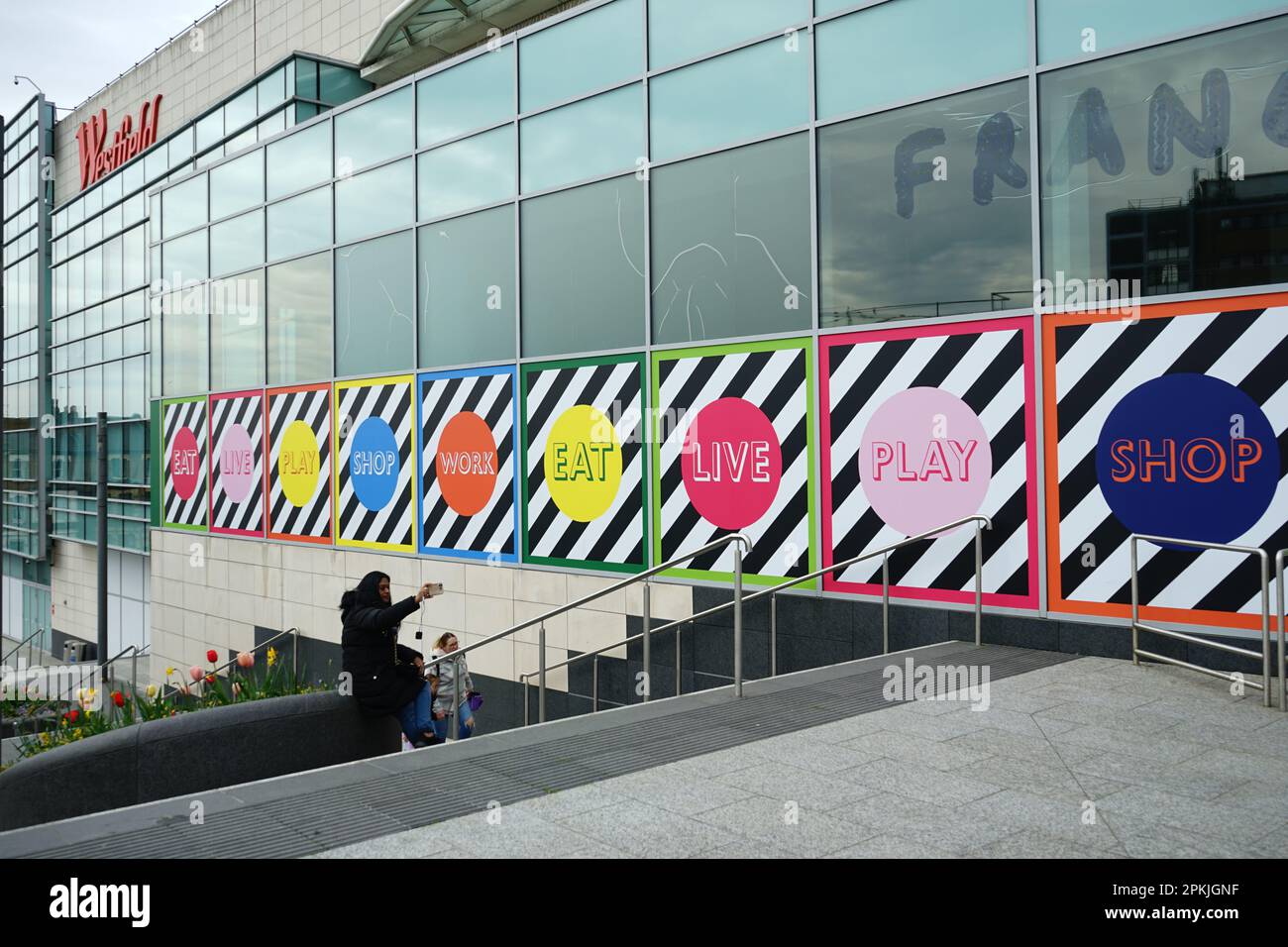 A colourful display on the walls of shops in the Westfield Shopping Centre, White City, west London Stock Photo