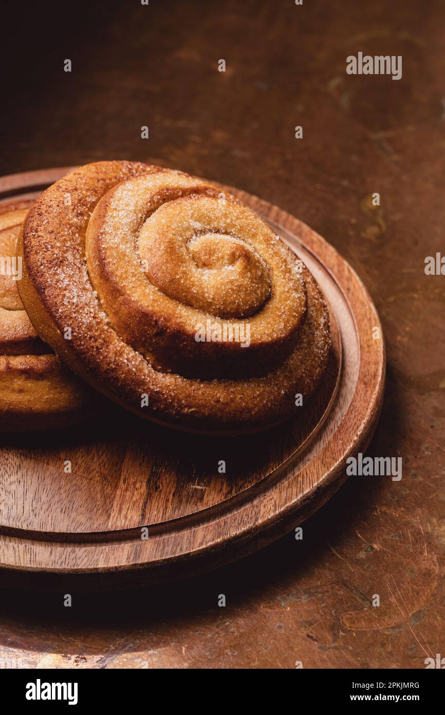 Cinnamon Rolls on a Wooden plate and a rustic table Stock Photo