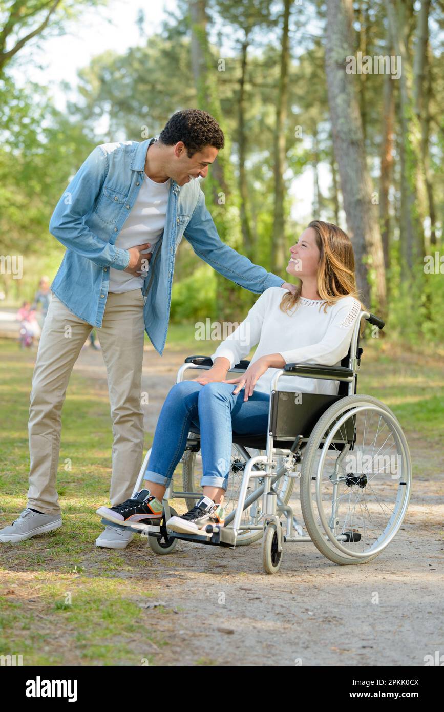 pretty woman in a wheelchair meeting man in the park Stock Photo - Alamy