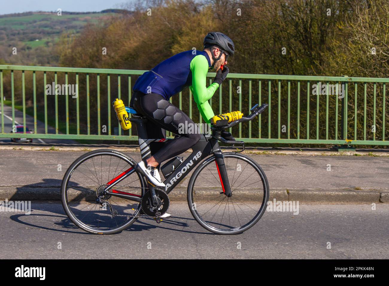 Male cyclist riding ARGON 18, Krypton Pro bicycle crossing motorway bridge in Greater Manchester, UK Stock Photo