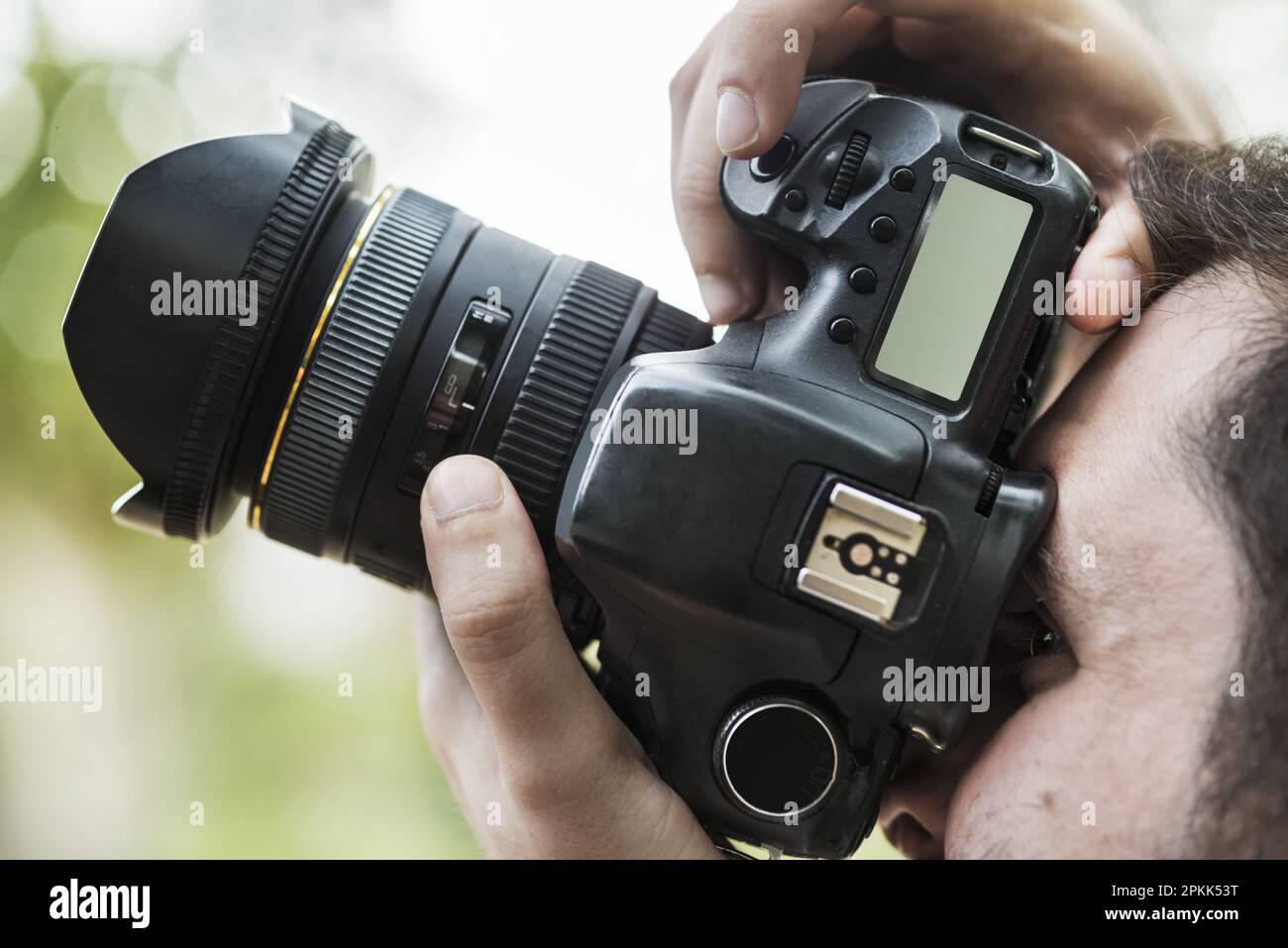 A photographer looking through the viewfinder of his camera to capture an image Stock Photo Alamy
