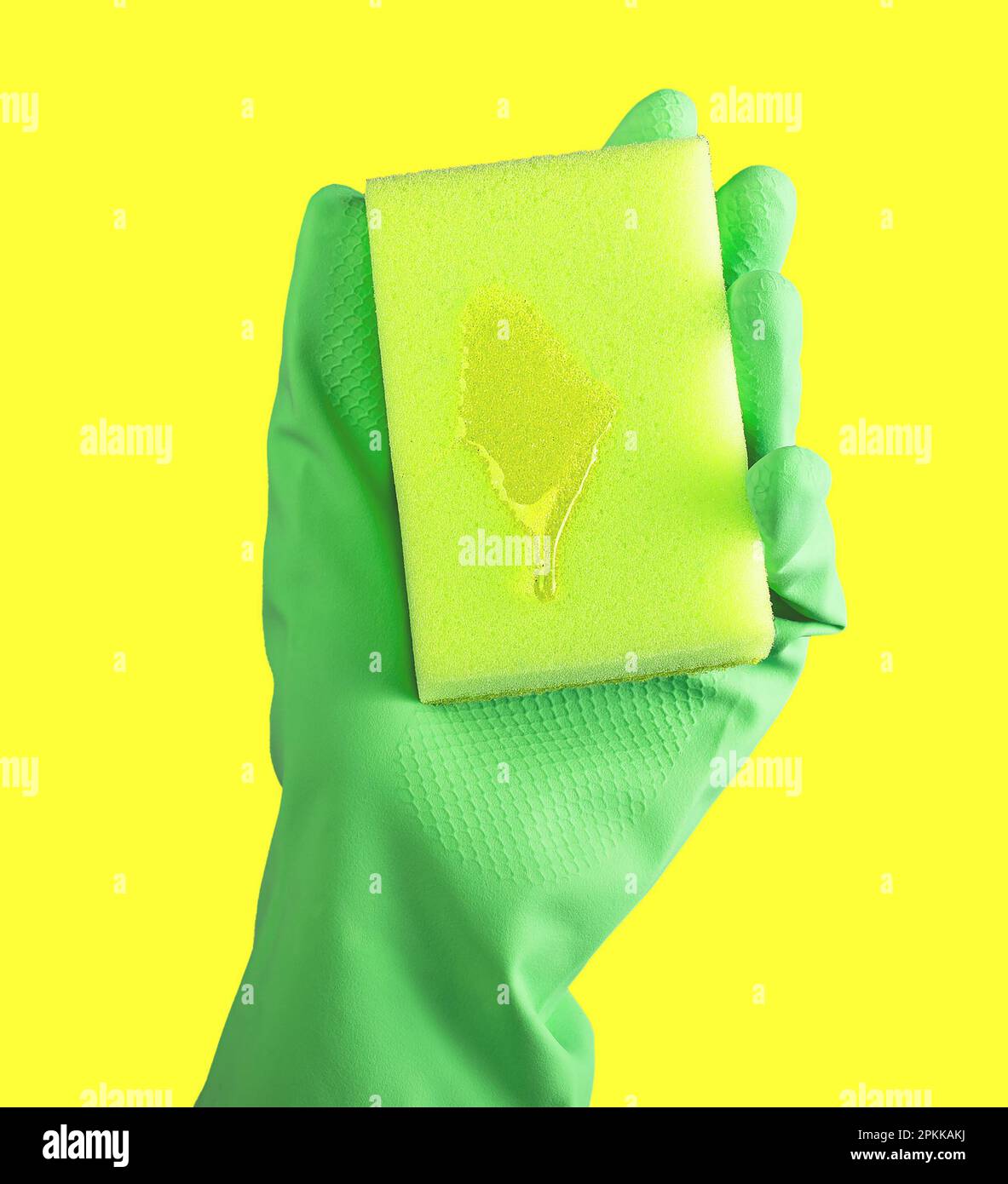 Hand in green glove holding cleaning sponge with liquid fluid detergent ...