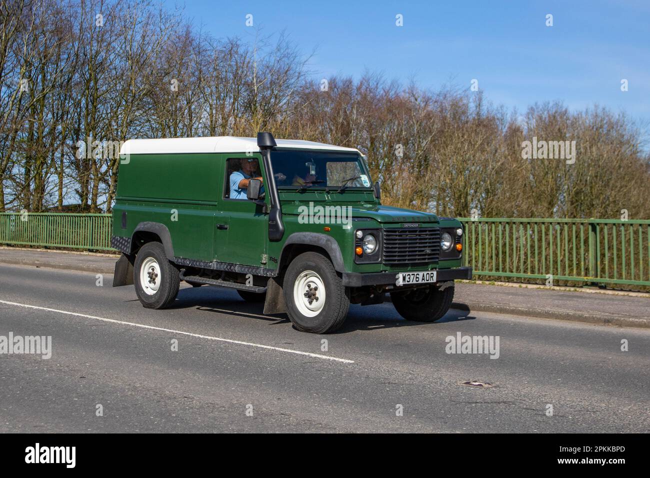 2000 Green Land Rover 110 Defender Tdi; crossing motorway bridge in Greater Manchester, UK Stock Photo