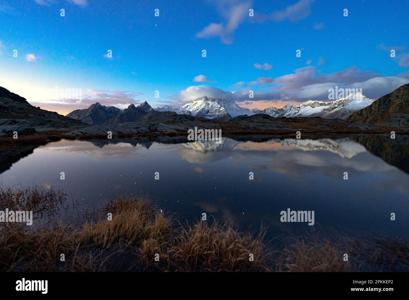 Snowy peak of Monte Disgrazia reflected in water at night, Alpe Fora, Valmalenco, Valtellina, Sondrio province, Lombardy, Italy, Europe Stock Photo