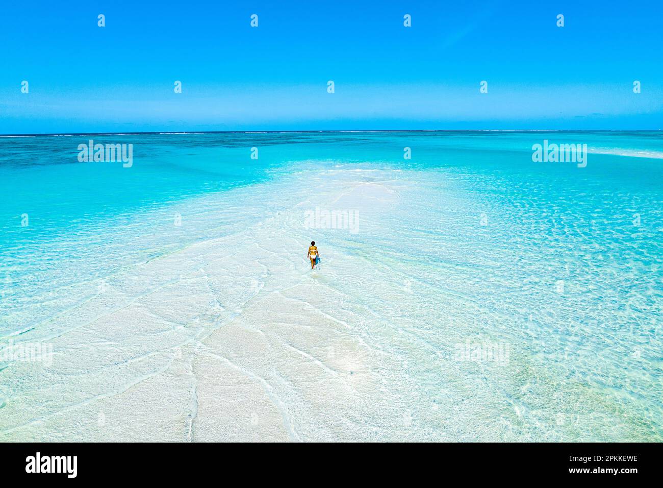 Aerial view of woman bathing in the transparent sea in the scenic sandbanks, Nungwi, Zanzibar, Tanzania, East Africa, Africa Stock Photo