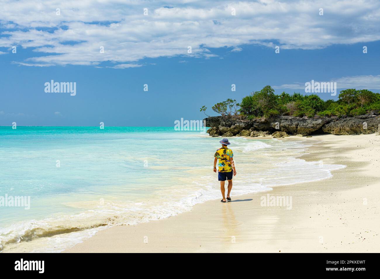 Mid adult man walking on empty sand beach, Nungwi, Zanzibar, Tanzania, East Africa, Africa Stock Photo
