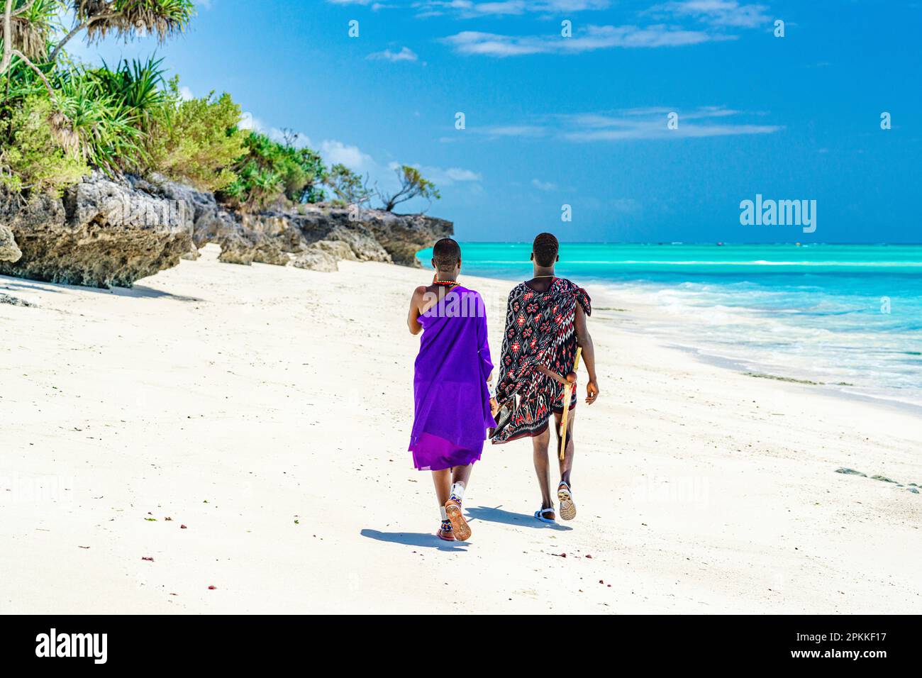 Couple of Maasai warriors enjoying walking on exotic beach, Zanzibar, Tanzania, East Africa, Africa Stock Photo
