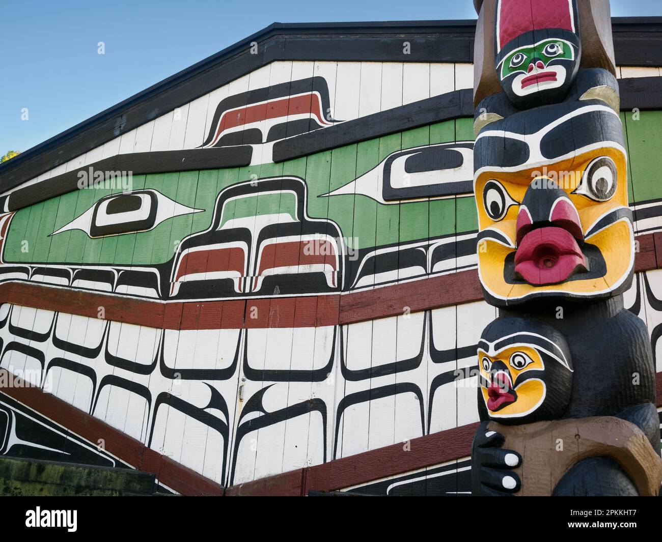 First Nations totem pole and Big House, Thunderbird Park, Vancouver Island, next to the Royal British Columbia Museum, Victoria, British Columbia Stock Photo