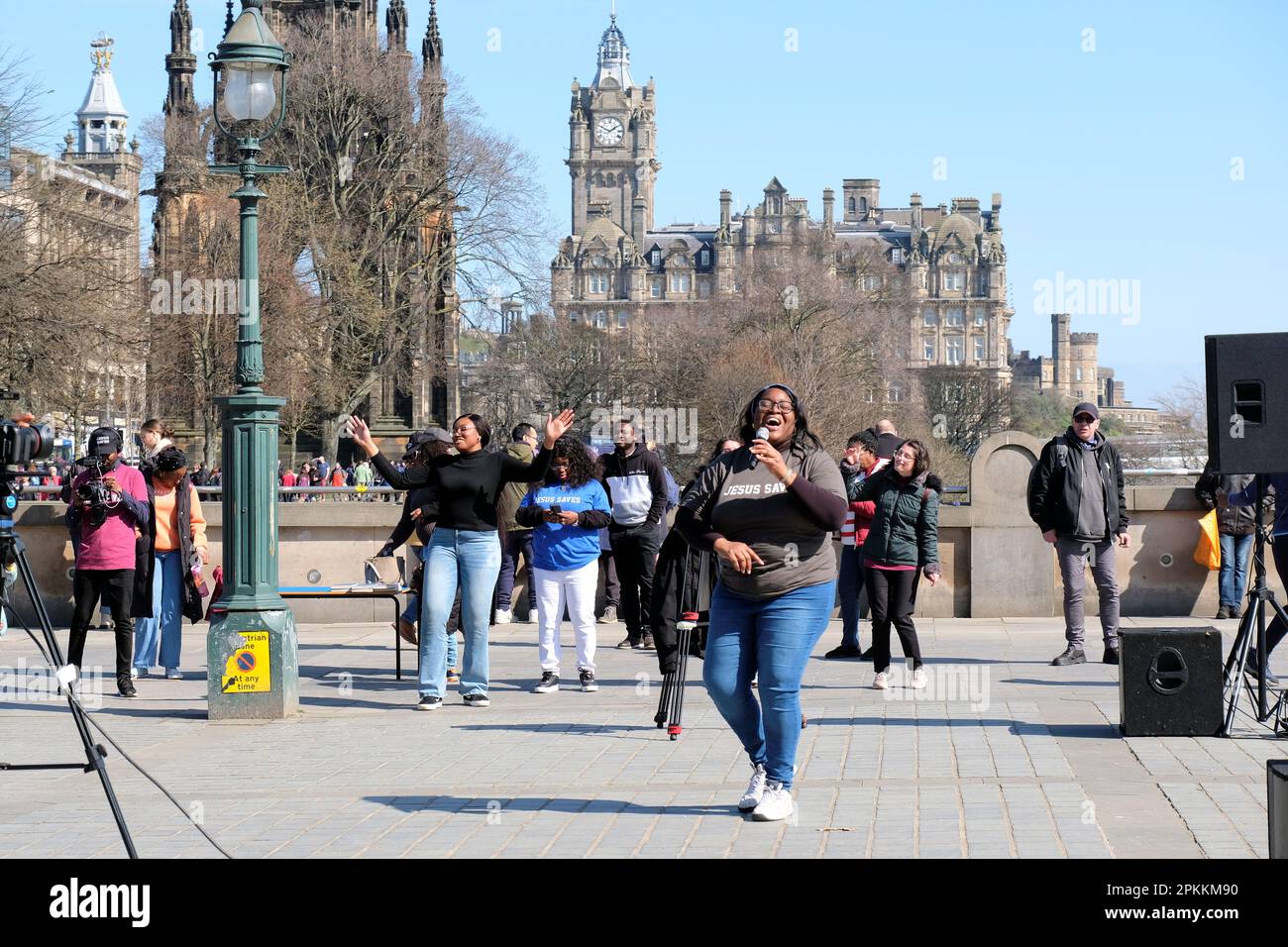 Edinburgh, Scotland, UK. 8th April 2023.  RCCG Edinburgh Tabernacle choir singing with gusto and entertaining holidaymakers and visitors at the Mound with the Balmoral Hotel as a backdrop.  Credit: Craig Brown/Alamy Live News Stock Photo