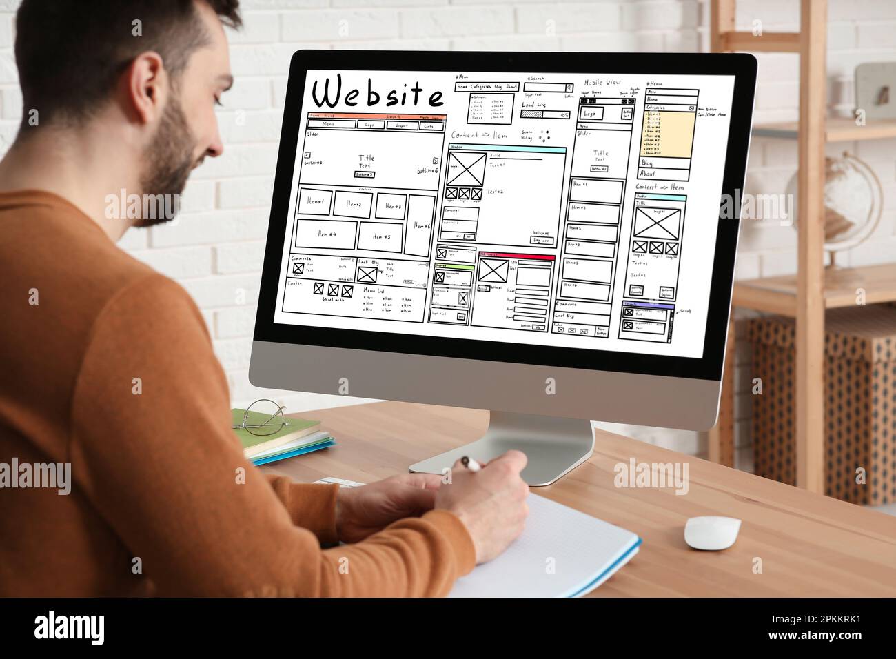 Designer creating website on computer at wooden table Stock Photo