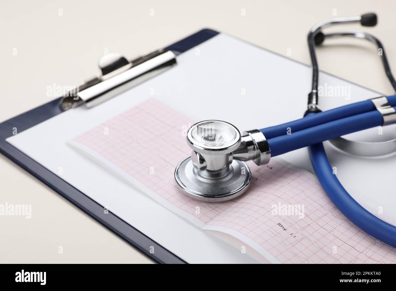 Stethoscope, clipboard and cardiogram paper on beige background ...