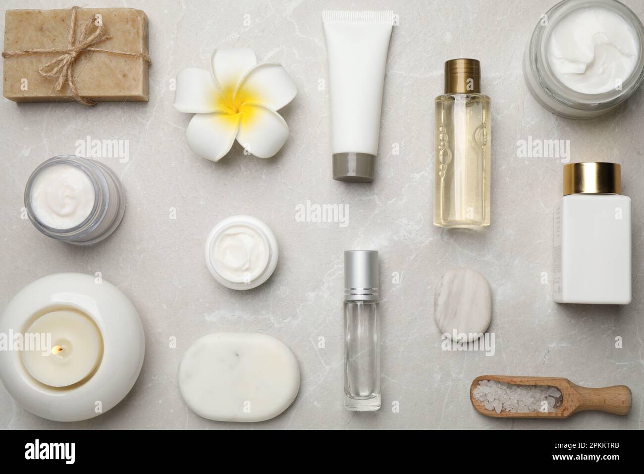 Flat lay composition with cosmetics and sea salt on grey marble table ...
