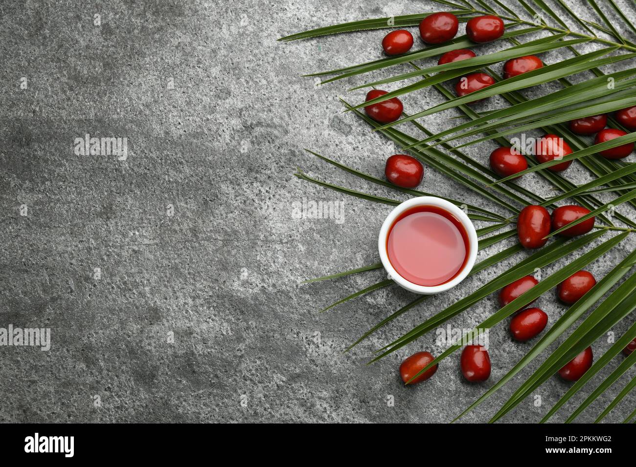 Flat lay composition with palm oil and fresh fruits on grey table ...
