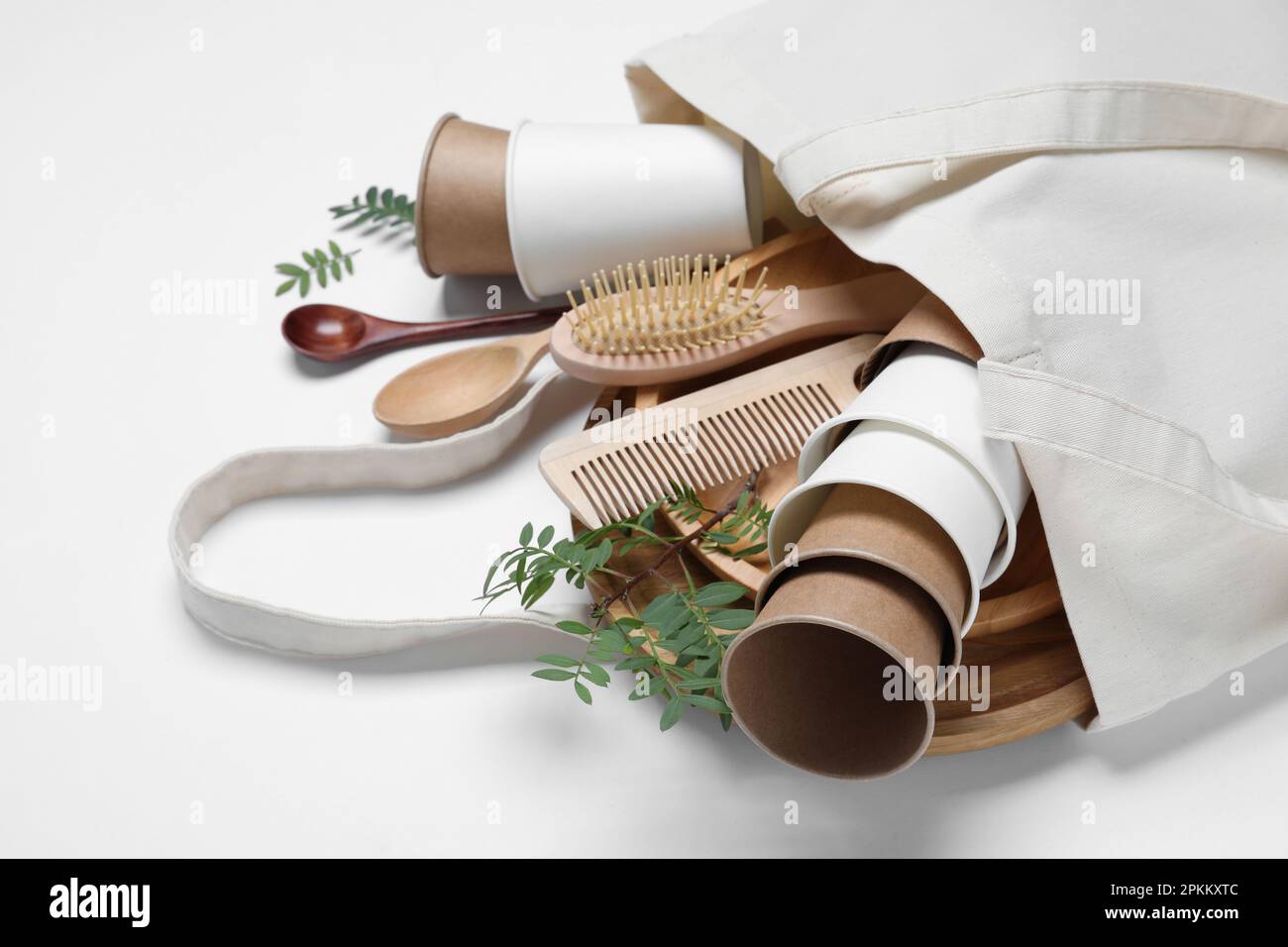 Eco bag with different disposable items on white background, closeup