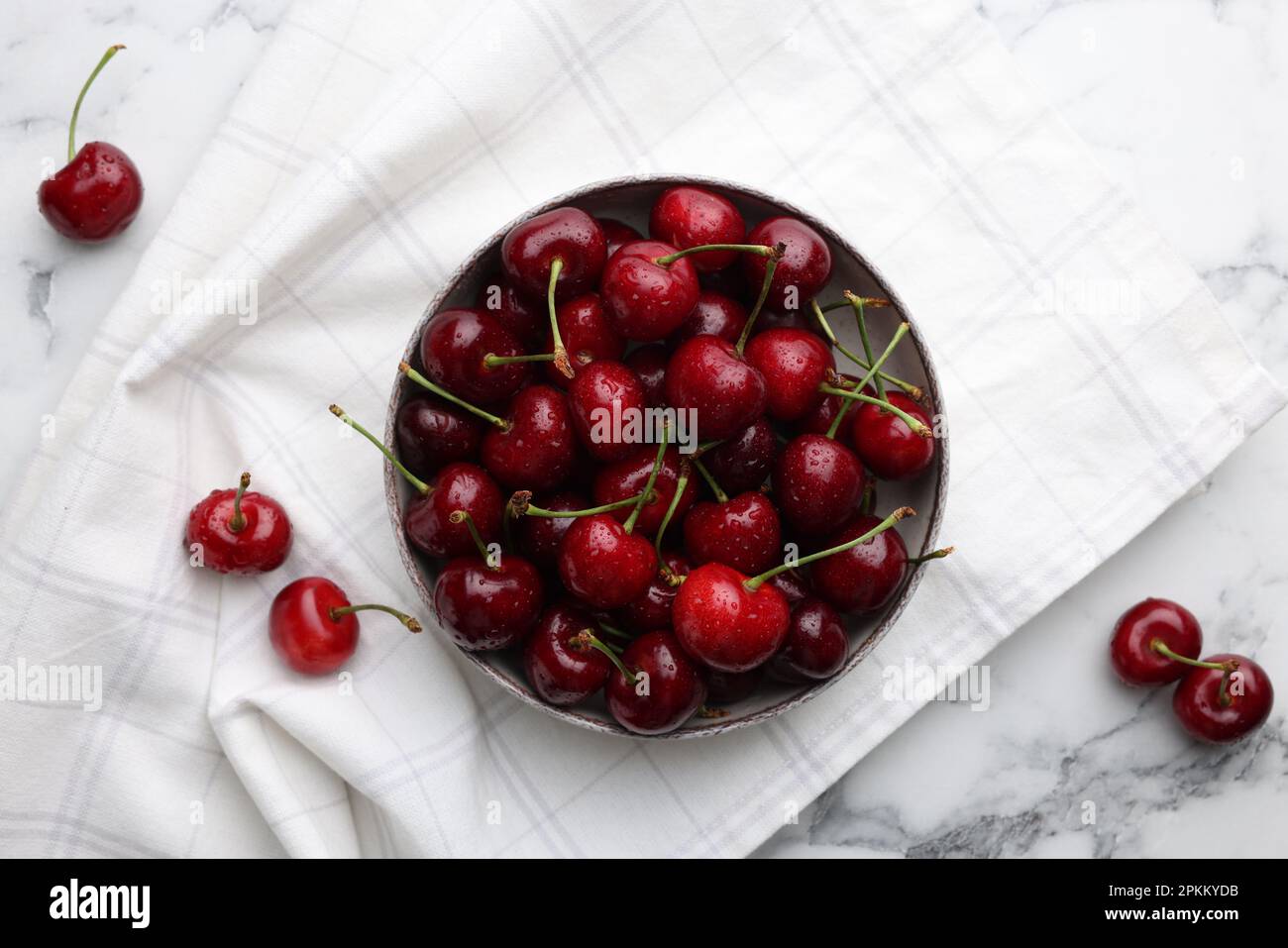 Fresh ripe cherries with water drops on white marble table, flat lay ...