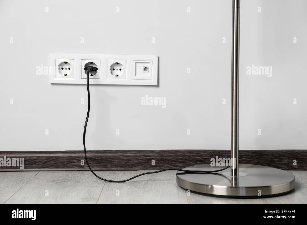 Floor lamp plugged into wall power socket indoors Stock Photo Alamy