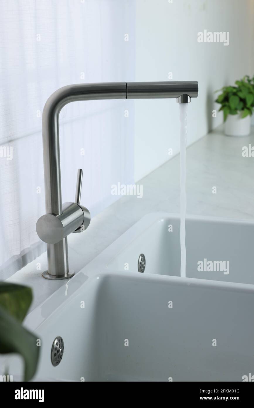 Stream of water flowing from tap in kitchen Stock Photo