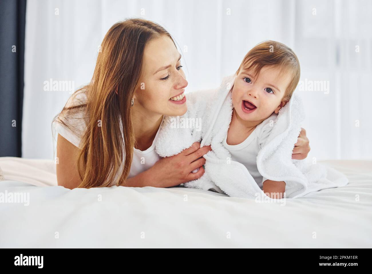 Conception of parenting. Mother with her little daughter is indoors at home together. Stock Photo