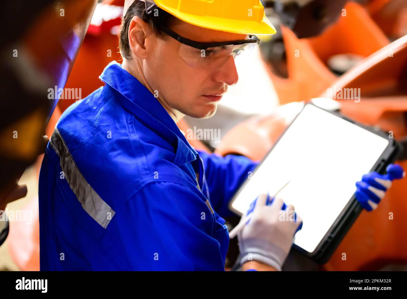 Expertise technician using digital tablet working at industrial plant Stock Photo