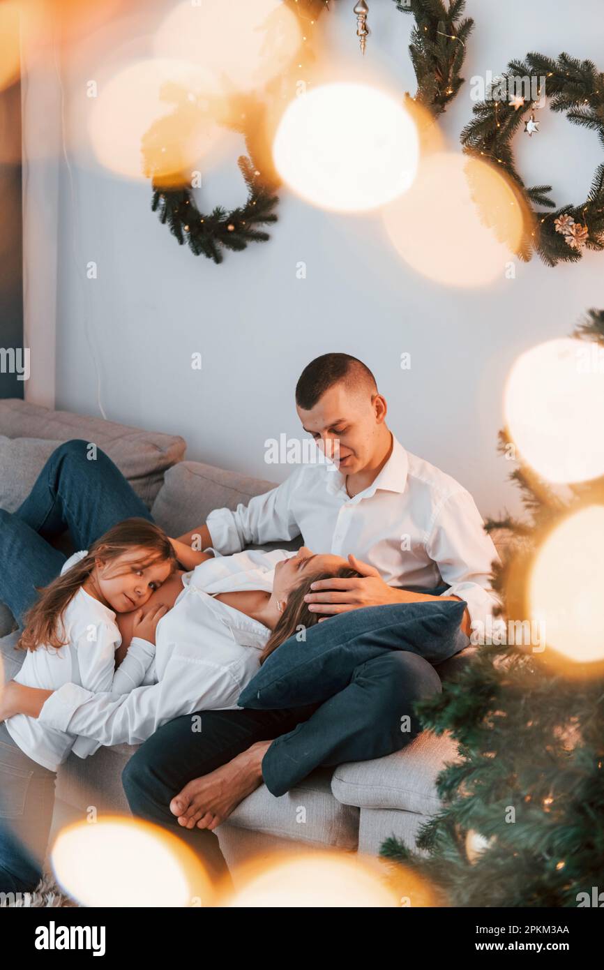 Laying down on the bed. Happy family celebrating holidays indoors together. Stock Photo