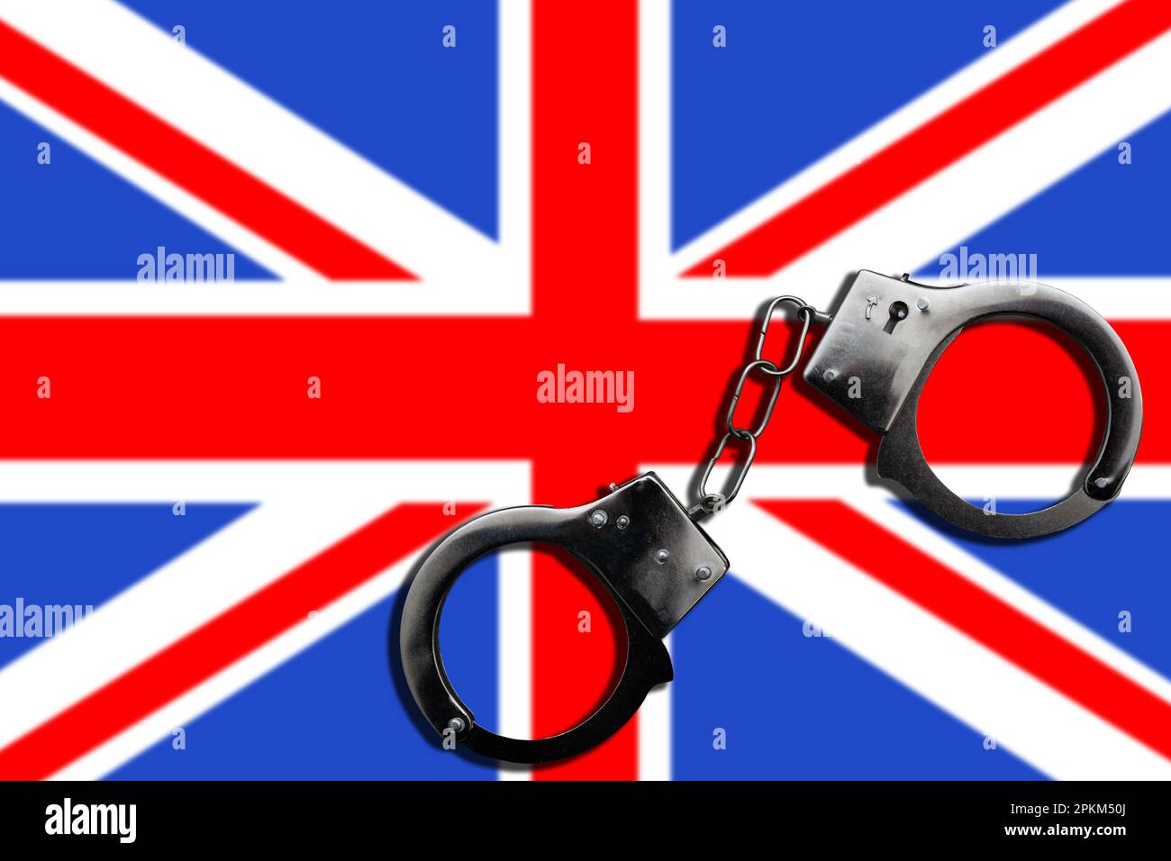 The concept of law and crime. There are handcuffs on the UK flag. Stock Photo