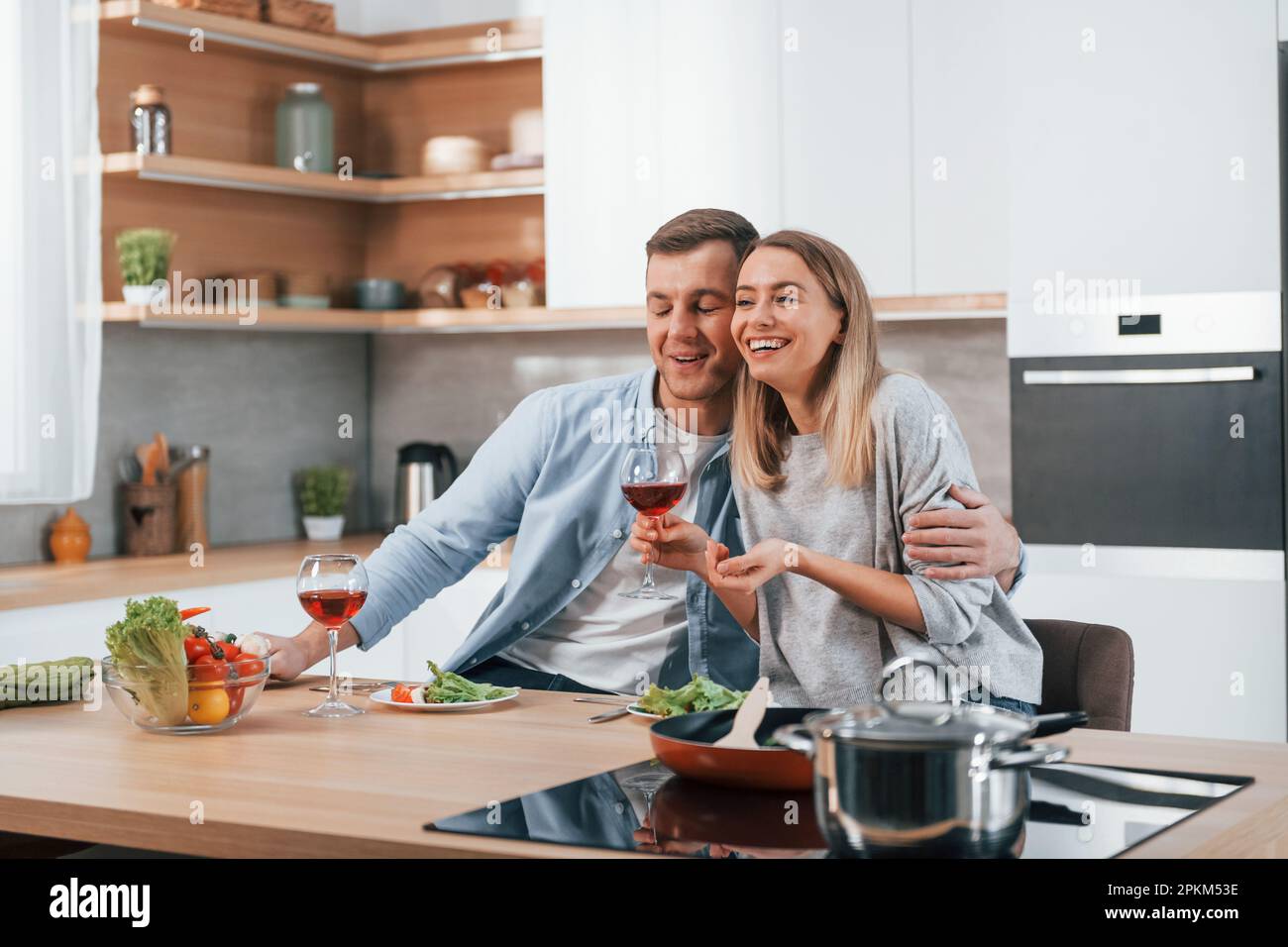 Having weekend together. Couple preparing food at home on the modern kitchen. Stock Photo