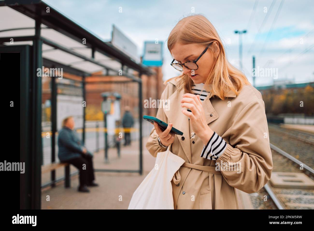 Happy female traveler by kiosk machine for travel application, document