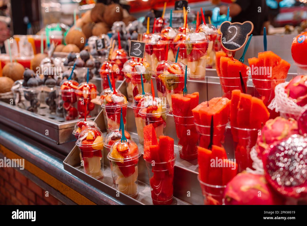 Assortment of fresh cut fruit in plastic containers in market grocery display case, Barcelona