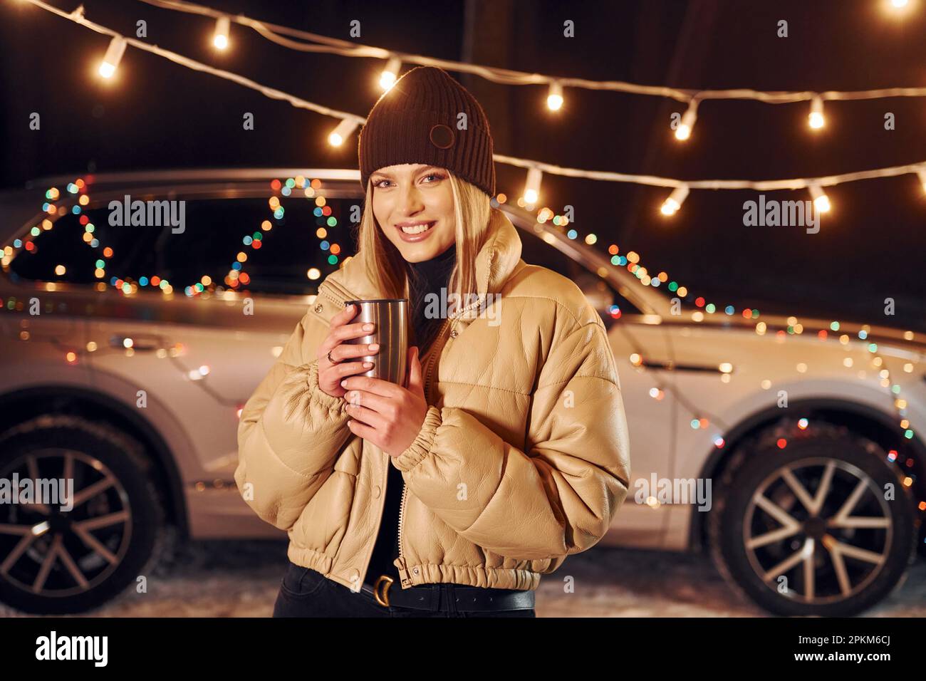 With thermos. Woman standing in the forest and celebrating New year. Stock Photo