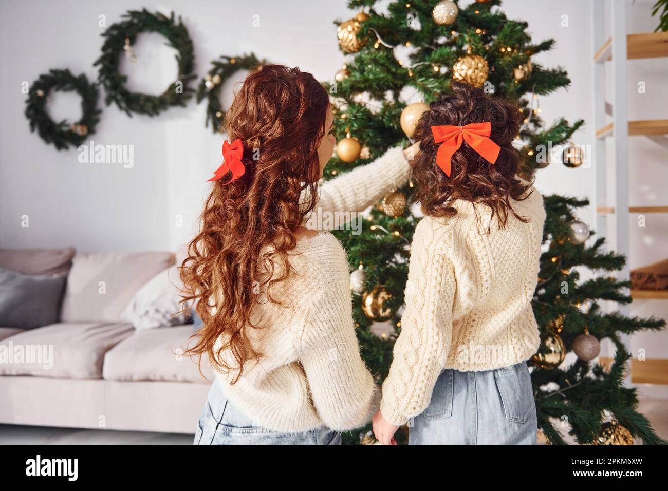 Decorating tree. Mother with her little daughter is at home. Stock Photo