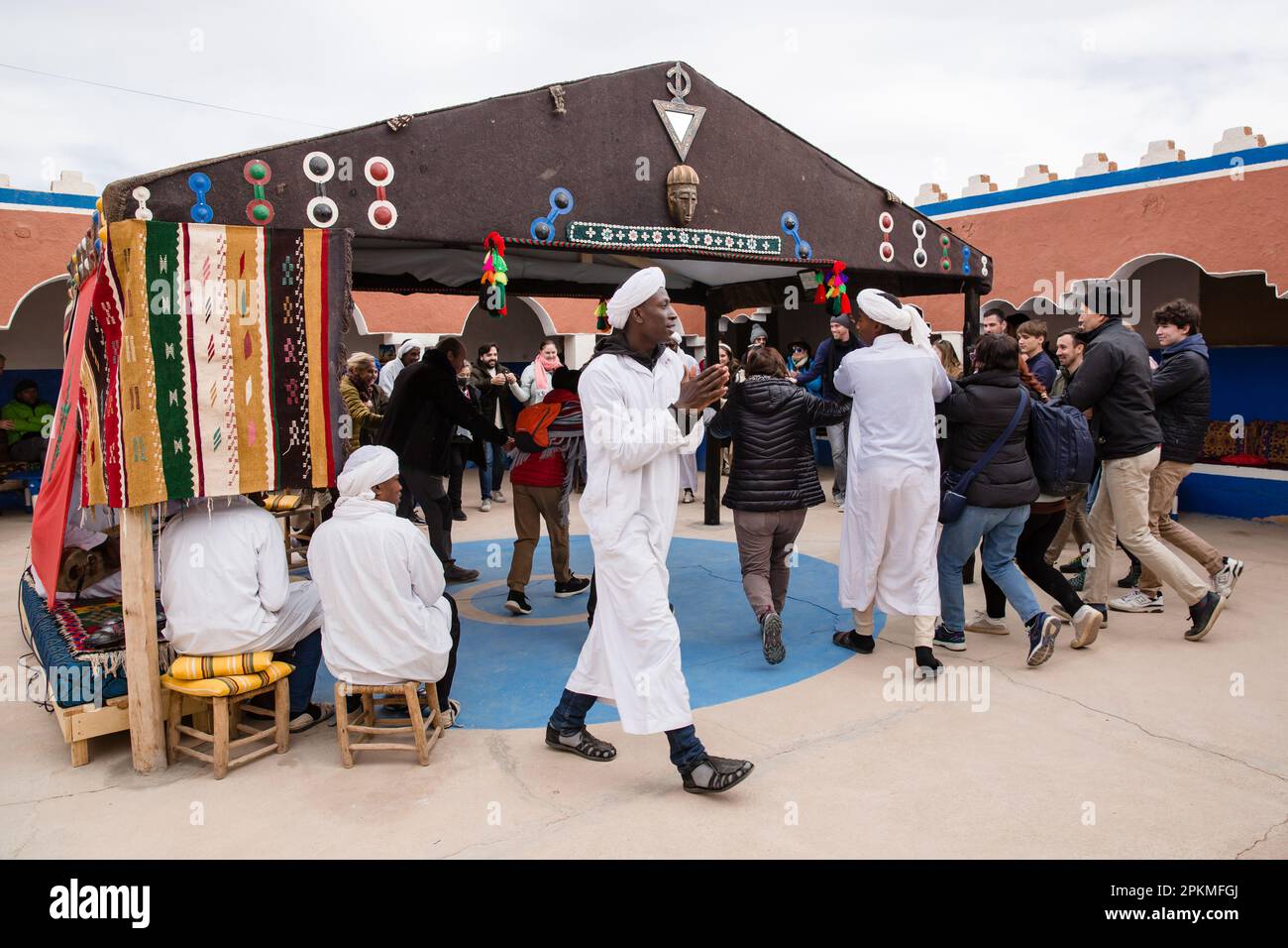 A group of tourists dance with local men at the Dar Gnaoua Bambara Khamlia Cultural Center Stock Photo