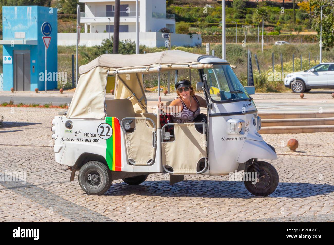 thumbs up from happy taxi driver in white tuk tuk taxi in albufeira