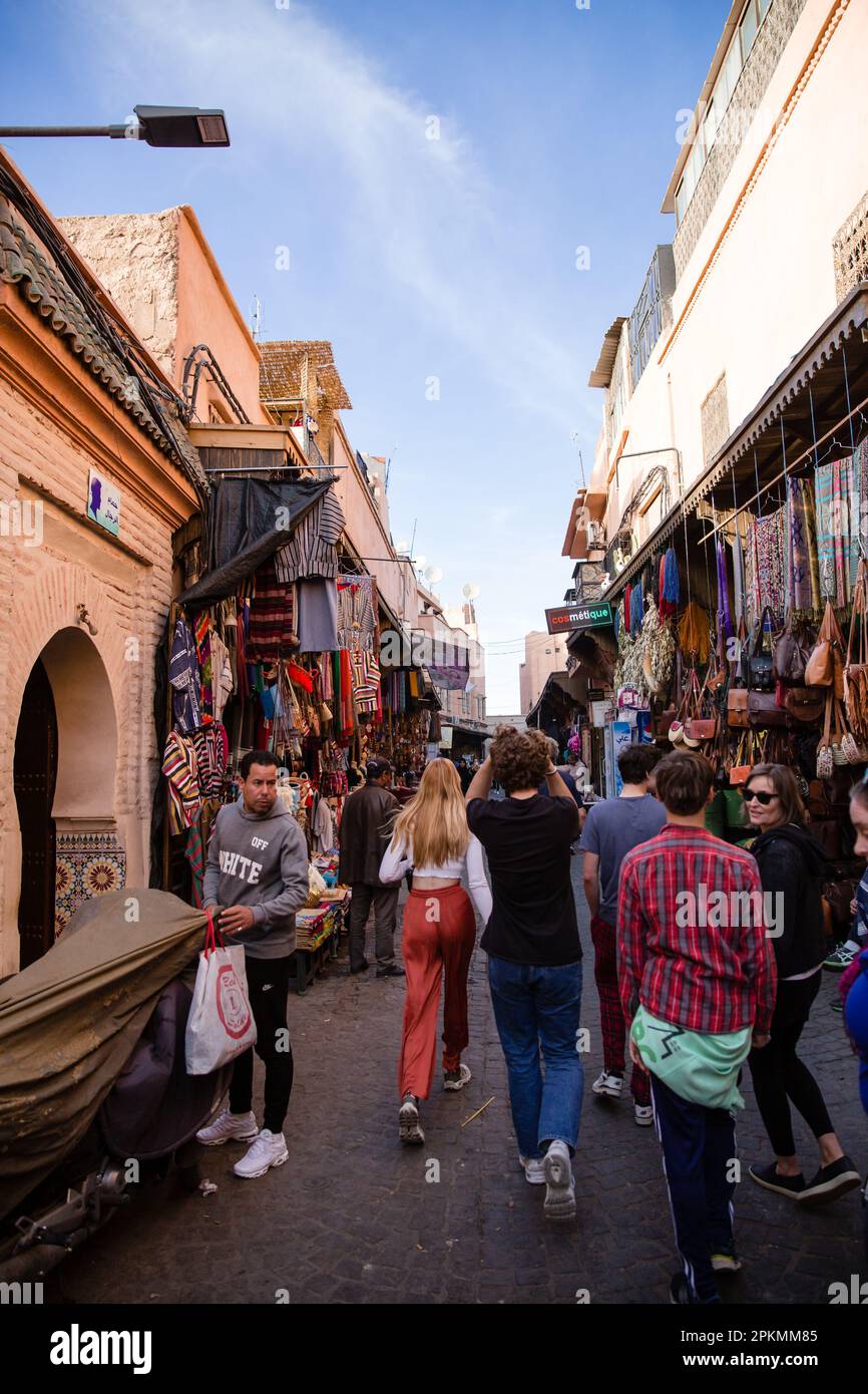 Tourists stroll among shops in a Marrakech medina souk Stock Photo