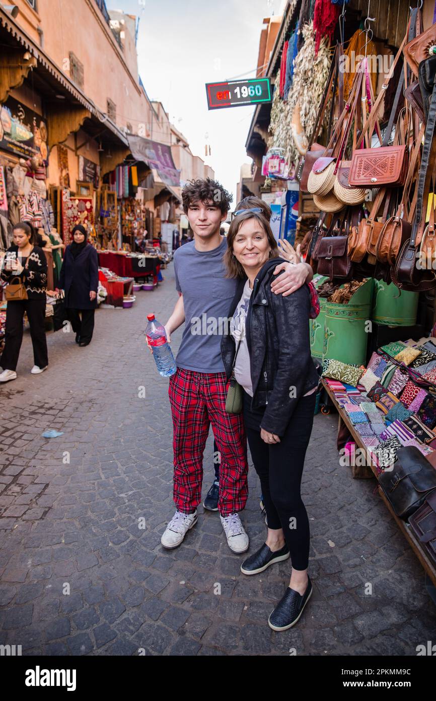 Mother & son tourists stand among shops in a Marrakech medina souk Stock Photo