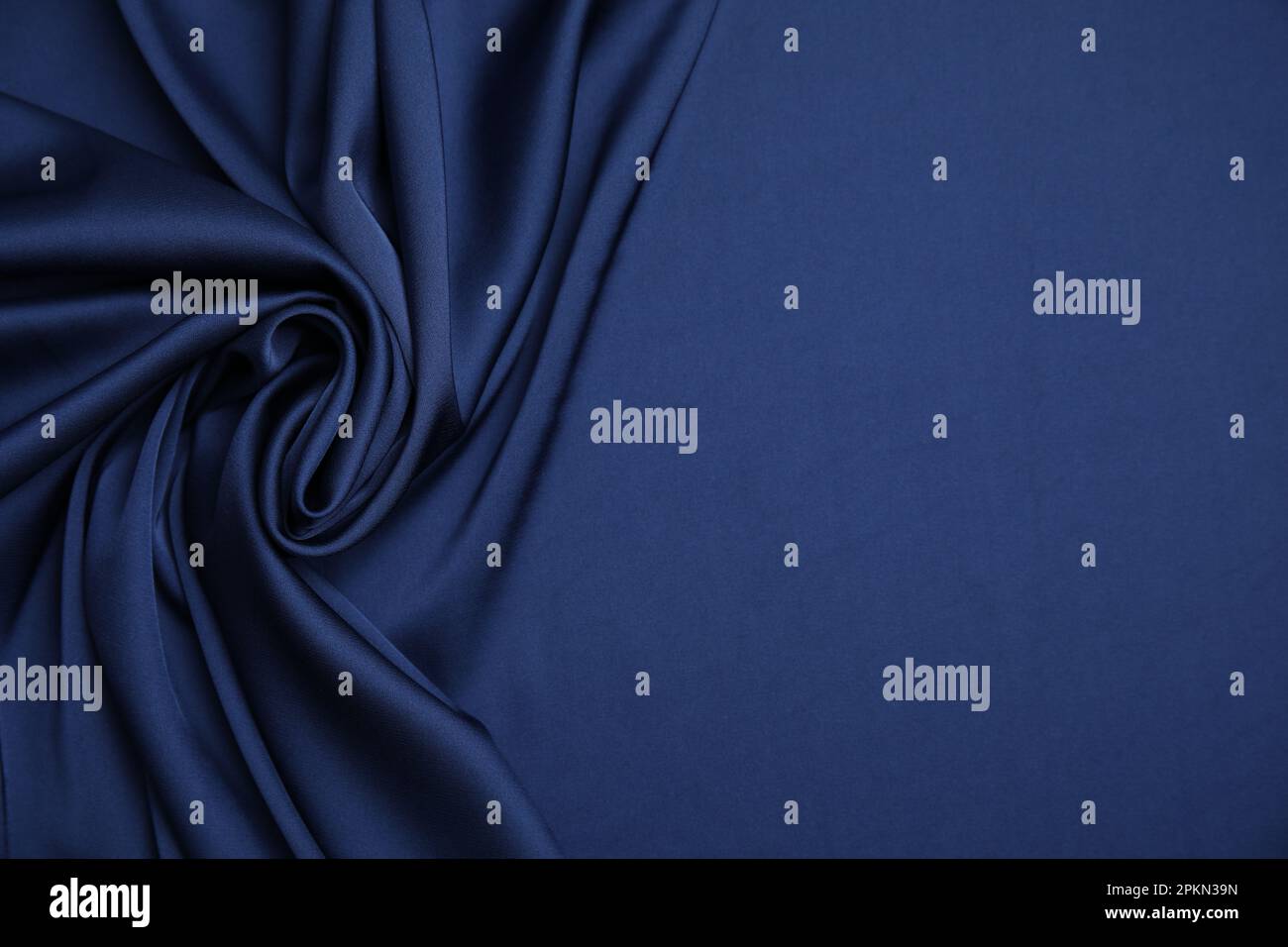 Crumpled dark blue silk fabric as background, top view. Space for text ...