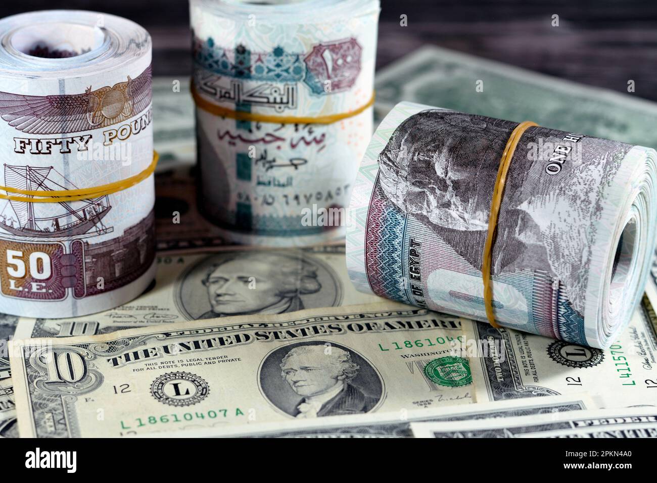 rolls-of-egypt-money-banknote-bills-of-100-and-50-egp-le-one-hundred-egyptian-and-fifty-pounds-on-usa-american-dollars-currency-old-vintage-notes-egy-2PKN4A0.jpg