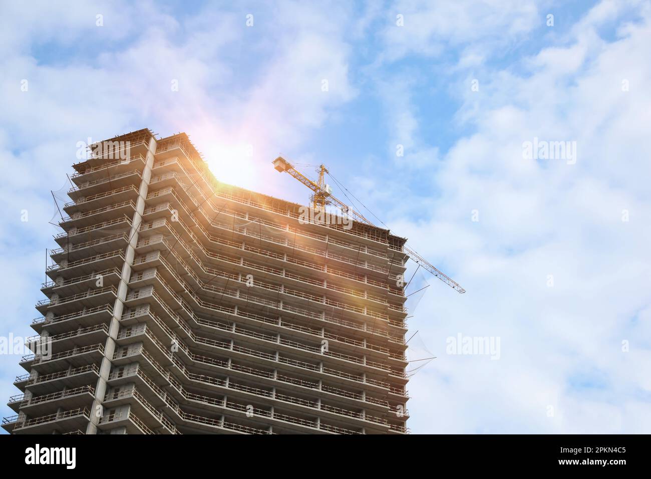 Multistoried residential building and construction crane outdoors, low angle view Stock Photo