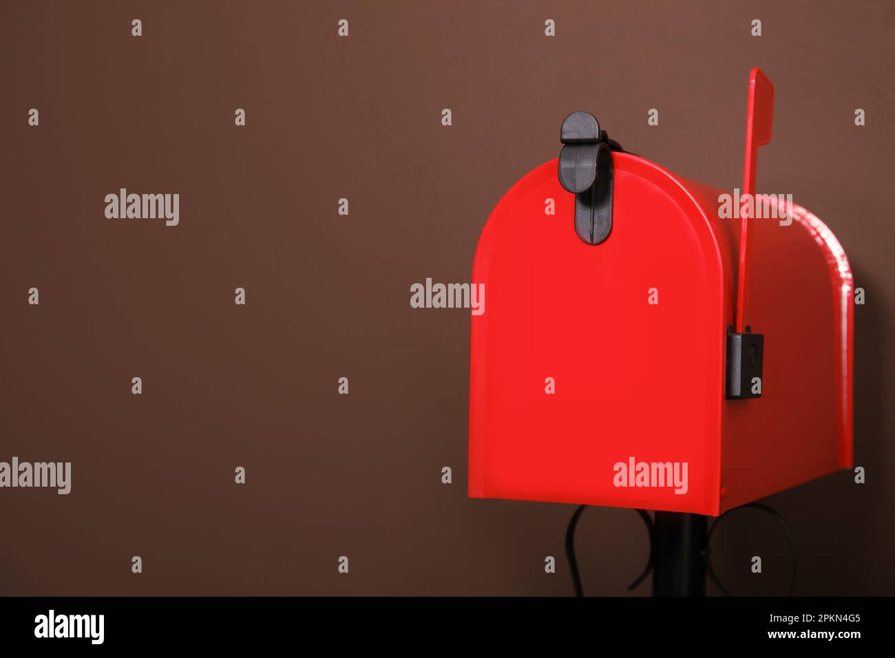 Closed red letter box against brown background. Space for text Stock