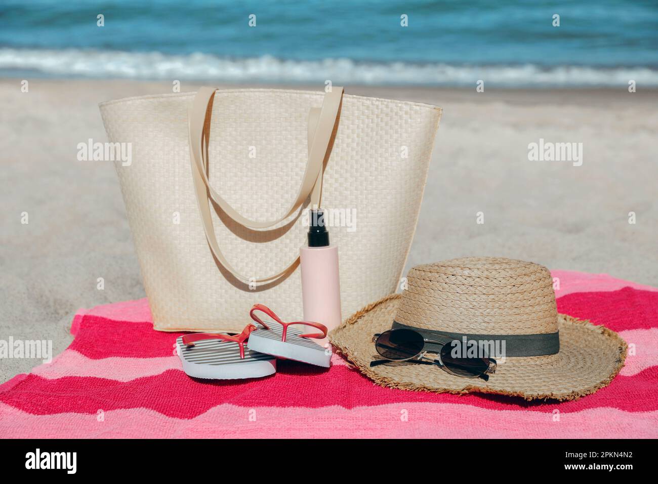 Straw hat, bag and other beach items on sandy seashore Stock Photo - Alamy
