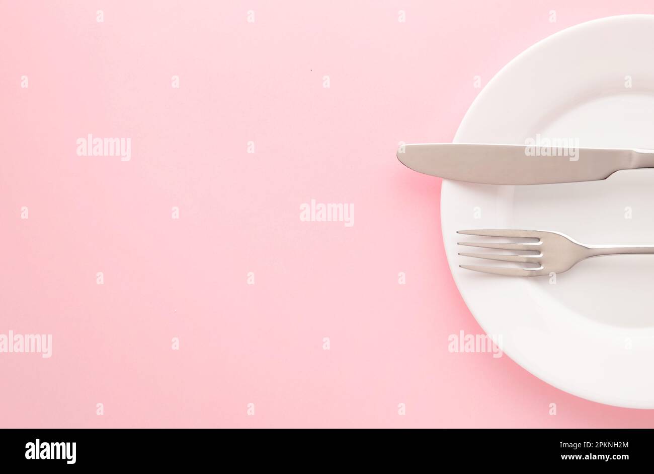 White empty plate with fork and knife on a pink table. Top view Stock ...
