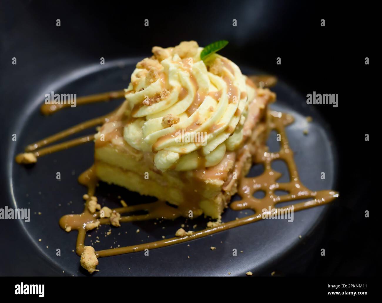 Tres leches cake or three milk cake in black plate on wooden table Stock Photo