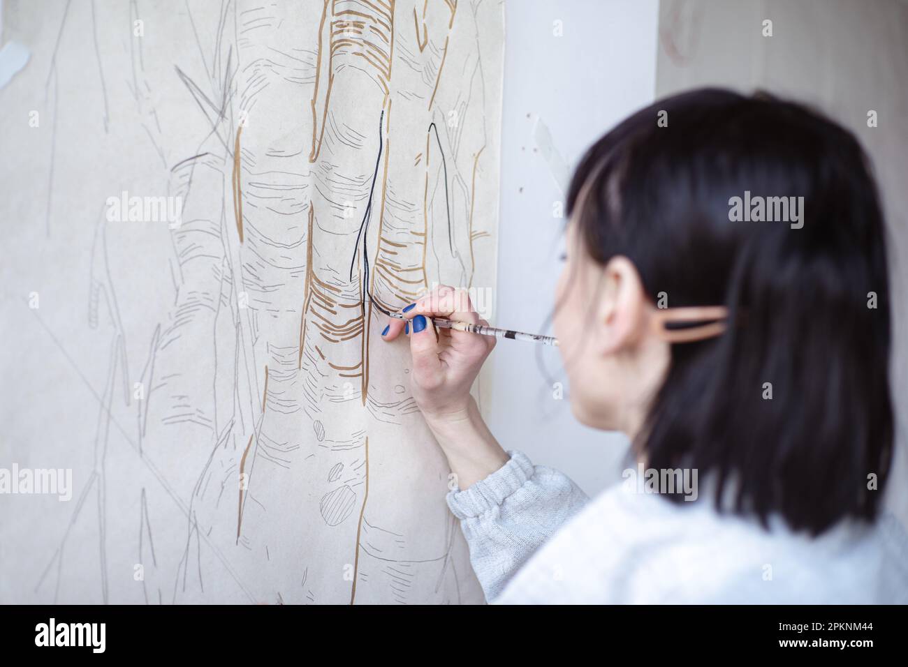 Female artist drawing painting with paint brush and black paint. Graphic Painting. Creating modern Art Stock Photo