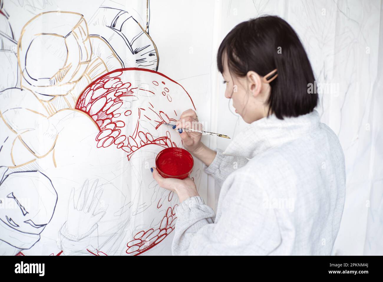 Female artist drawing painting with paint brush and black paint