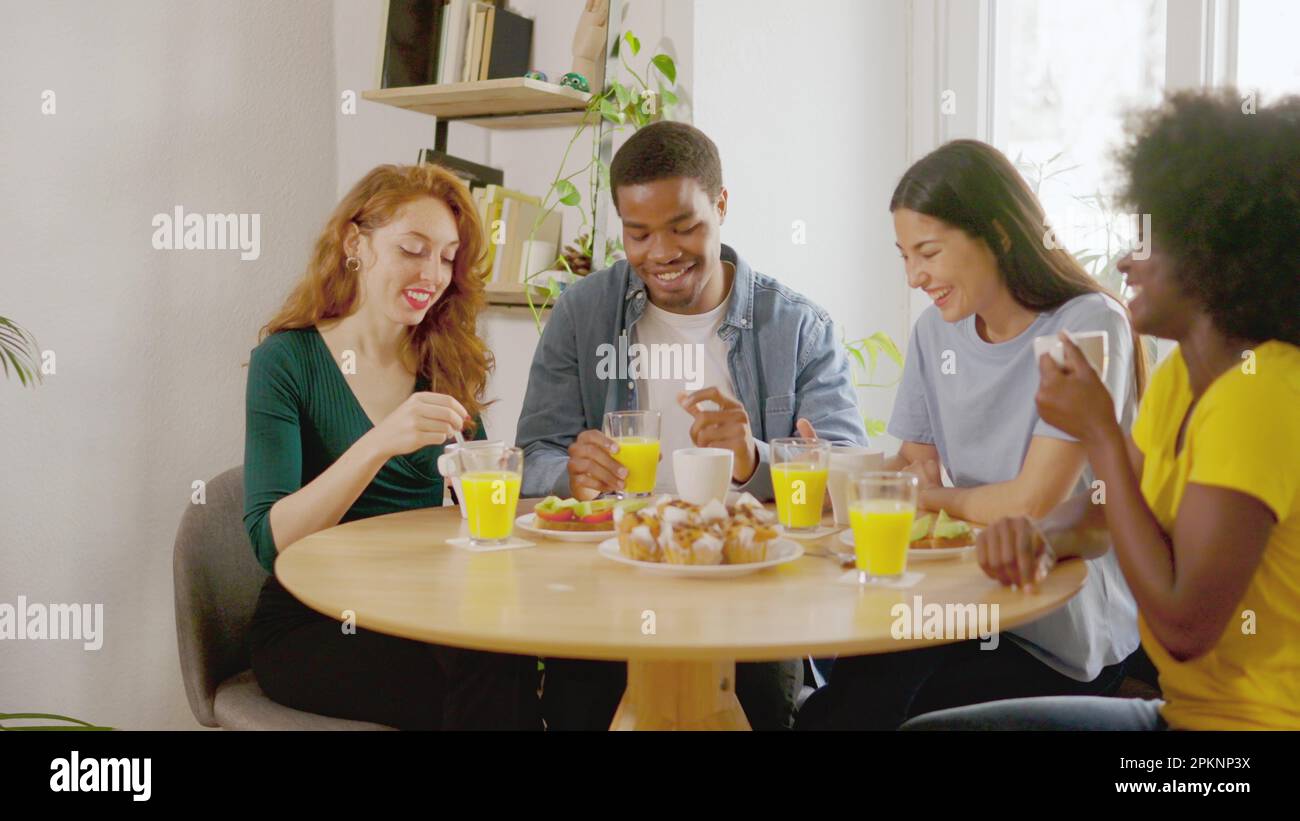 Multiethnic friends talking while having breakfast at home Stock Photo