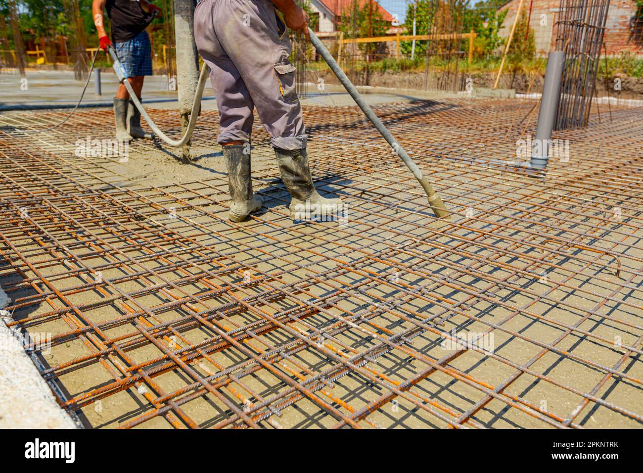 Worker is using vibration power tool, compactor, for compacting fresh ...