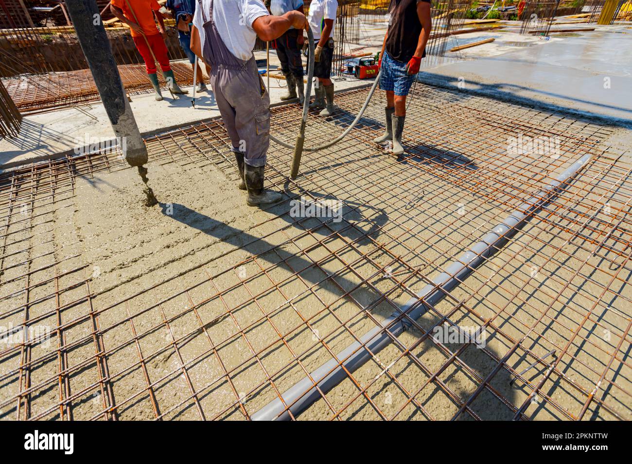 Worker is using vibration power tool, compactor, for compacting fresh ...