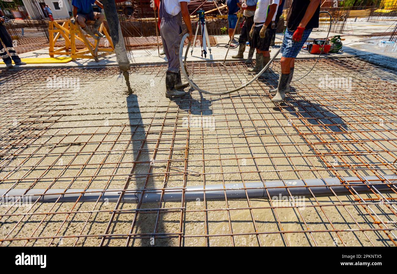 Worker is using vibration power tool, compactor, for compacting fresh ...