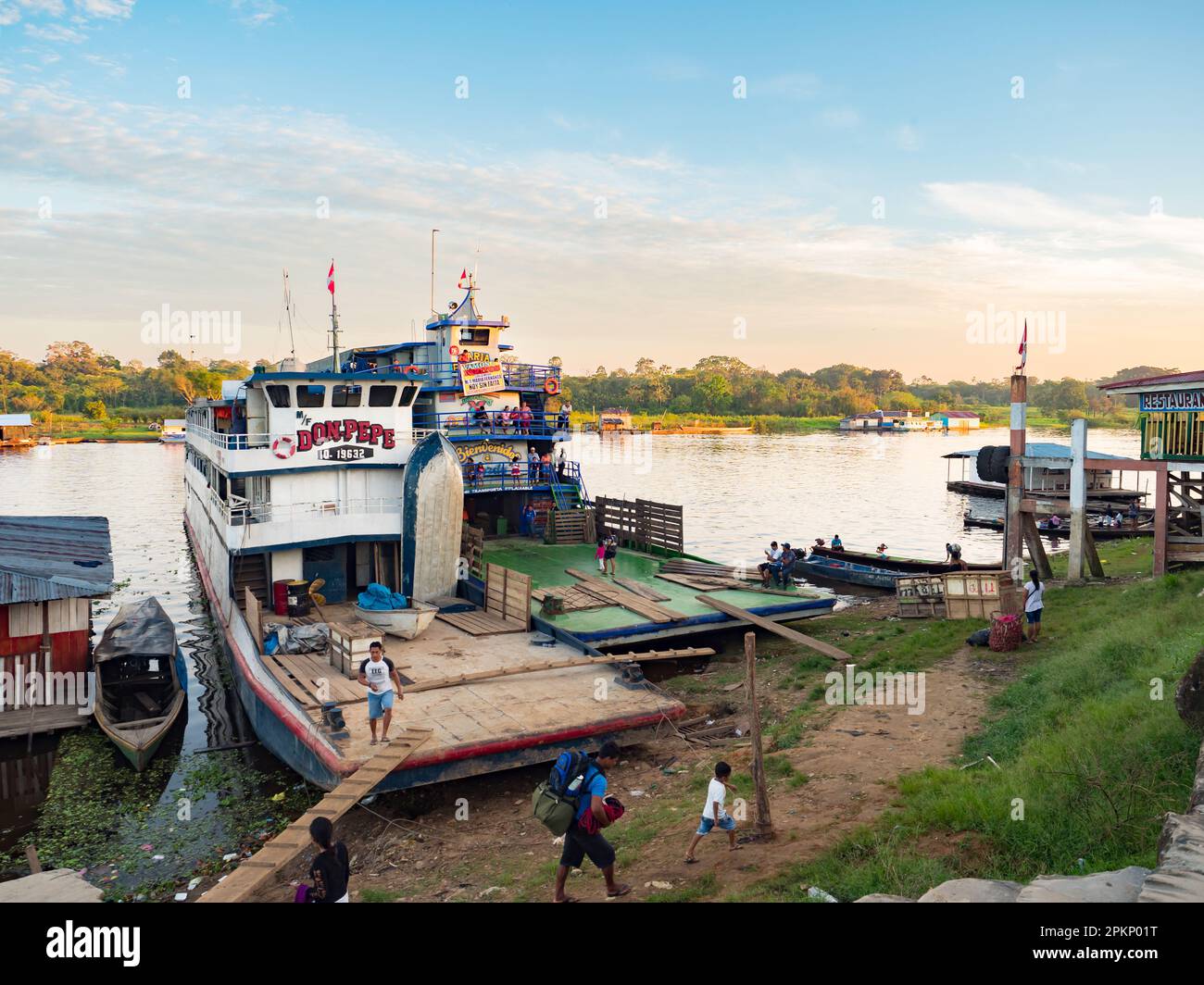 Santa Rosa, Peru - Mar,  2018: Sunrise over the Amazon river and the cargo boat waiting at the port. Stock Photo