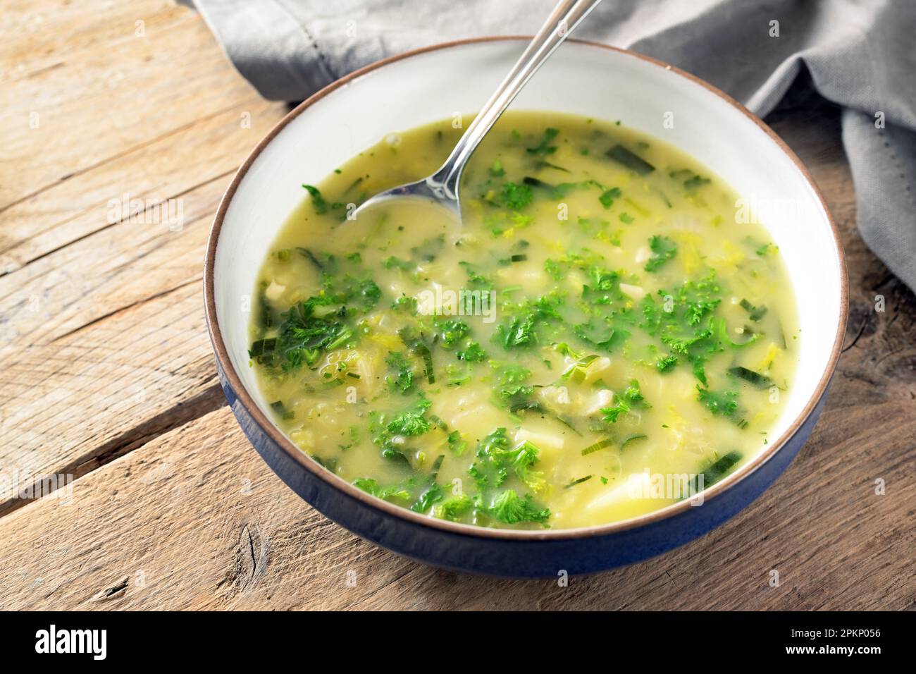 Potato parsley soup in a plate with spoon on a rustic wooden table, healthy vegetarian dish, copy space, selected focus, narrow depth of field Stock Photo