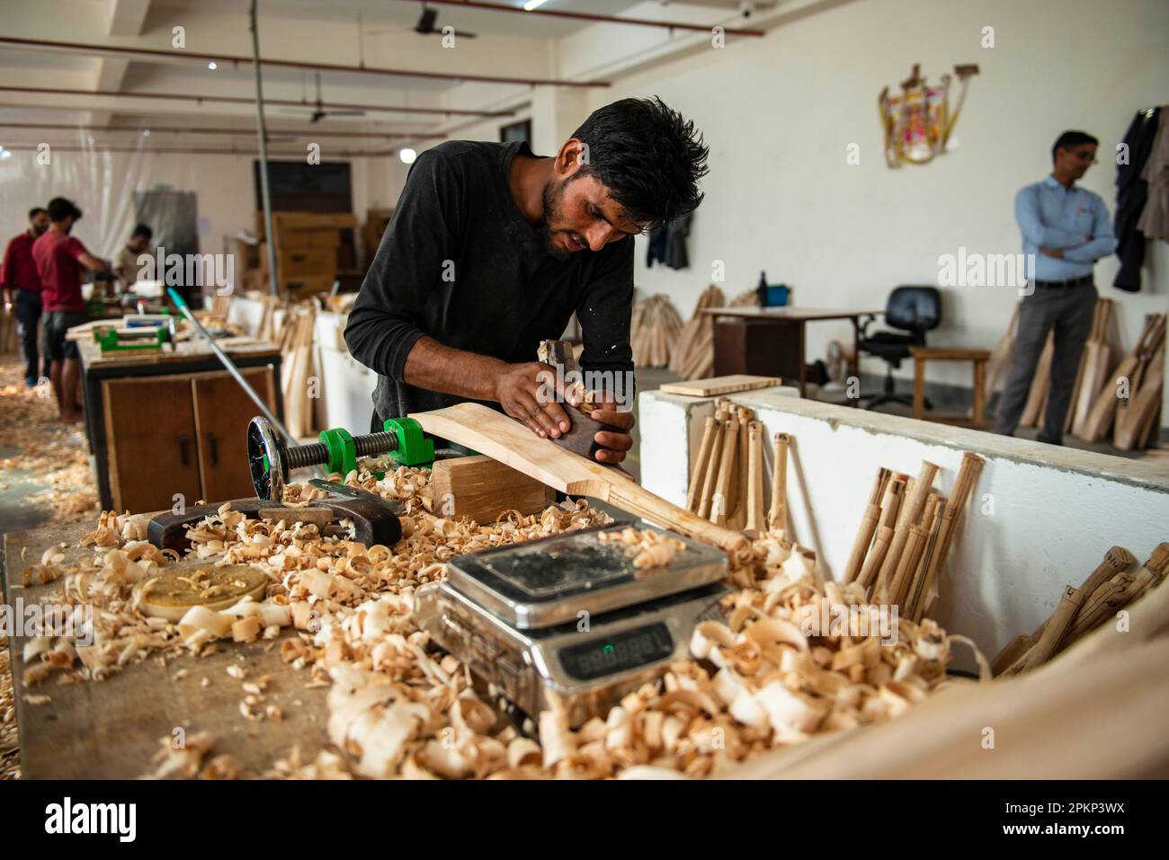 A worker uses hand planes to shape cricket bats at the Stanford cricket